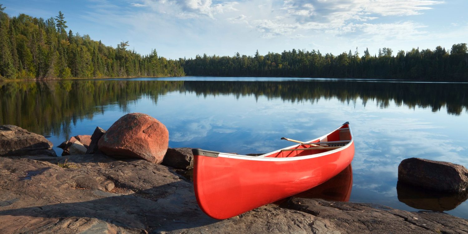 a canoe resting on the lakeshore