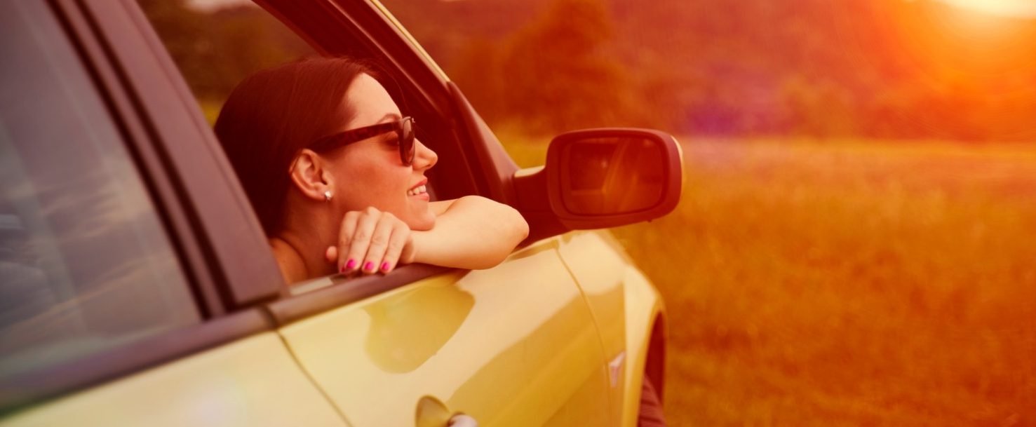 weekendtripfrompittsburgh – Edited Woman enjoying a weekend trip from Pittsburgh at the window of her car at sunset