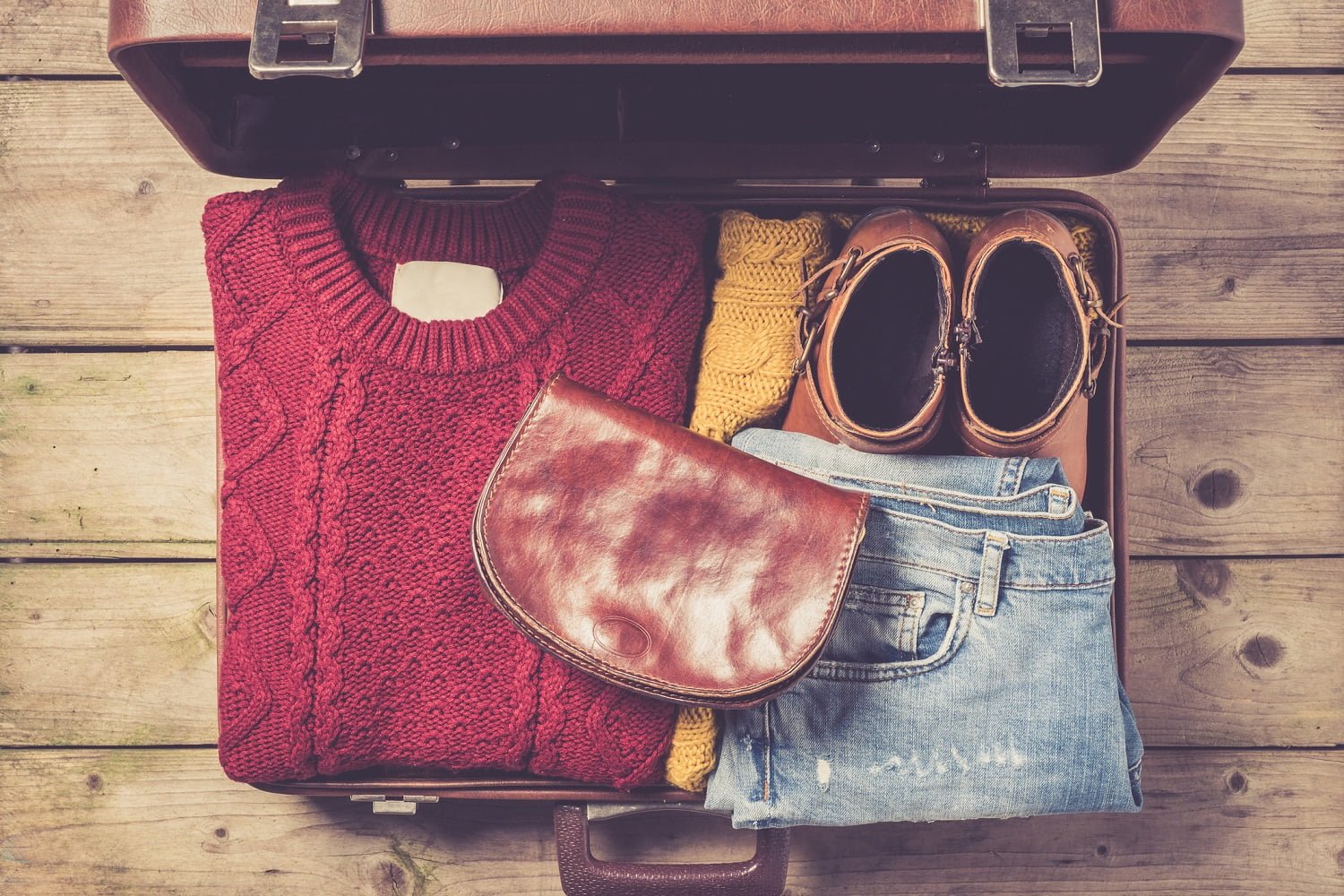 Open suitcase with casual female clothes for one night getaway in Ohio
