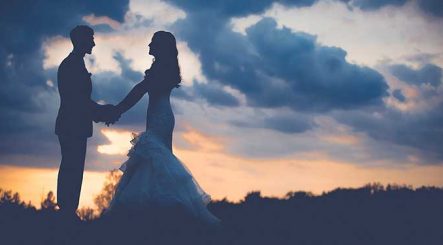 Bride and Groom on a Hillside at Sunset